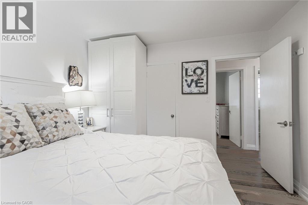 Built-in cabinetry, wood-finish flooring, and white interior doors - 2105 Maplewood Drive, Burlington, ON - Indoor Photo Showing Bedroom
