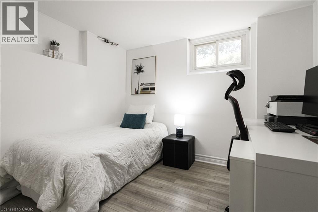 Wood-finish flooring with white walls and a white-framed window - 2105 Maplewood Drive, Burlington, ON - Indoor Photo Showing Bedroom