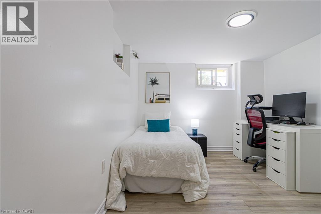 Recessed window, wood-finish flooring, built-in shelving, and a flush-mount ceiling light - 2105 Maplewood Drive, Burlington, ON - Indoor Photo Showing Bedroom