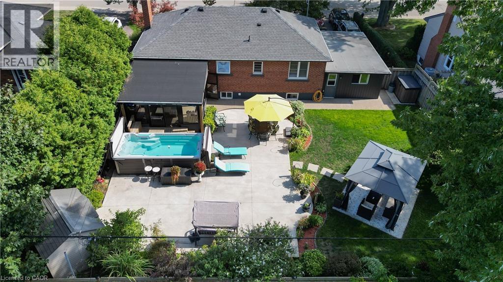 Expansive concrete patio featuring an in-ground swim spa with a retractable cover - 2105 Maplewood Drive, Burlington, ON - Outdoor