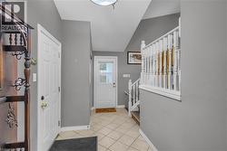 Entryway featuring a white paneled door, light gray walls, and diamond-patterned tile flooring - 
