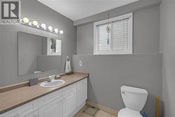 Bathroom featuring a vanity with an integrated sink, broad countertop, and white cabinetry - 