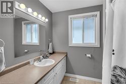 Bathroom featuring a single vanity with an integrated sink, ample counter space, and white cabinetry - 