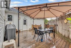 Wood-plank outdoor deck featuring a gazebo, privacy fencing, and direct exterior access - 