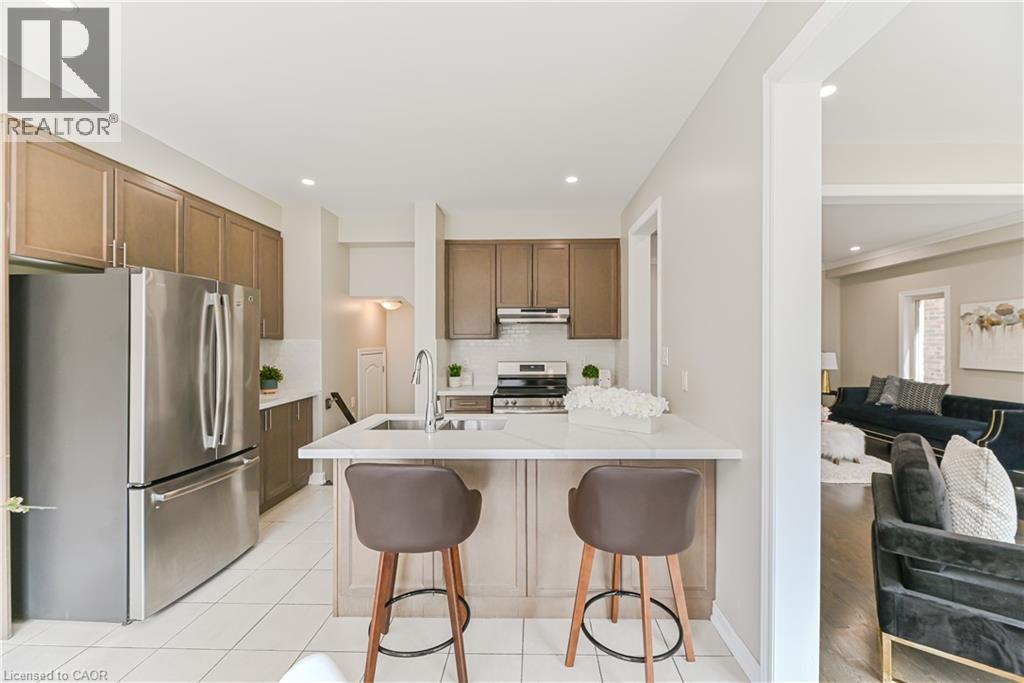 Kitchen featuring stainless steel appliances, upper and lower cabinetry, an undermount sink, and a countertop island with seating - 24 Weatherall Avenue, Cambridge, ON - Indoor Photo Showing Kitchen With Upgraded Kitchen