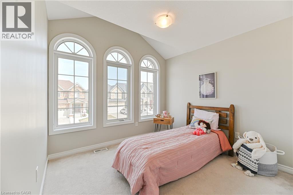 Three arched windows with white frames, vaulted ceiling, light-toned wall paint, and plush carpeting - 24 Weatherall Avenue, Cambridge, ON - Indoor Photo Showing Bedroom