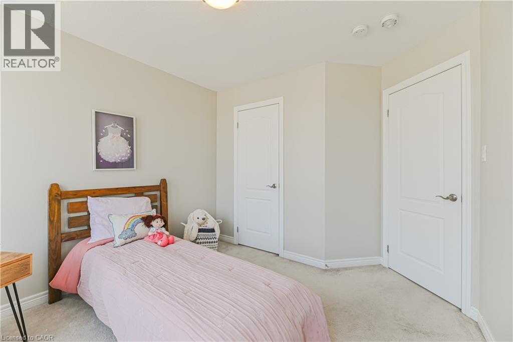 Neutral wall color, wall-to-wall carpeting, two panel doors with hardware, and ceiling-mounted light fixture - 24 Weatherall Avenue, Cambridge, ON - Indoor Photo Showing Bedroom