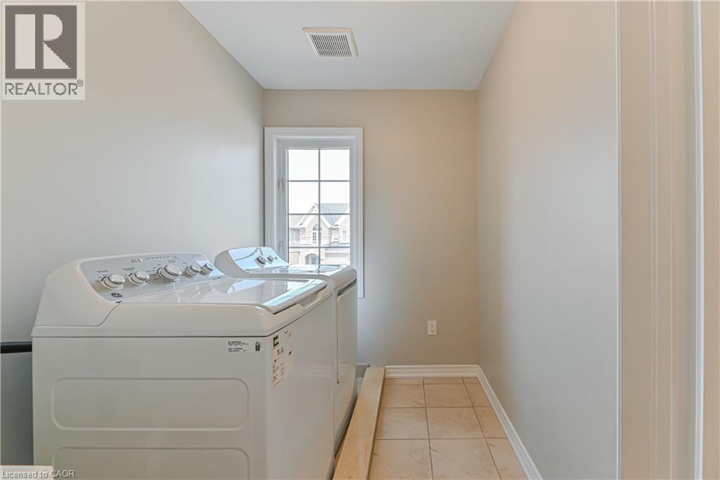 Tiled flooring, light-toned wall paint, a framed window, and white trim details - 24 Weatherall Avenue, Cambridge, ON - Indoor Photo Showing Laundry Room