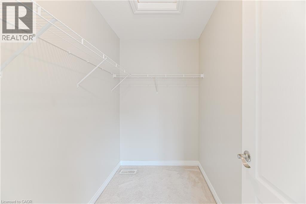 Recessed ceiling light with white trim, white wire shelving, light-toned carpeting, white baseboards, and a white interior door with brushed nickel hardware - 24 Weatherall Avenue, Cambridge, ON - Indoor With Storage
