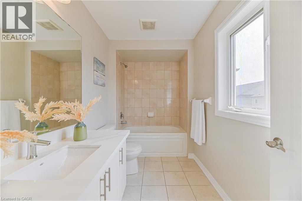 Bathroom featuring a single vanity with an undermount sink, a large mirror, a tiled shower/tub combination, and tiled flooring - 24 Weatherall Avenue, Cambridge, ON - Indoor Photo Showing Bathroom