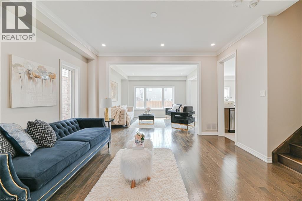 Wide plank wood-finish flooring throughout, featuring a bright, open living space with recessed lighting and crown molding - 24 Weatherall Avenue, Cambridge, ON - Indoor Photo Showing Living Room