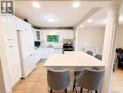 Kitchen featuring white cabinetry, light-toned wood-finish flooring, recessed lighting, and a kitchen island with a light-colored countertop - 