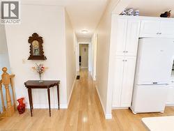 Light wood-finish flooring extending through the hallway and kitchen - 