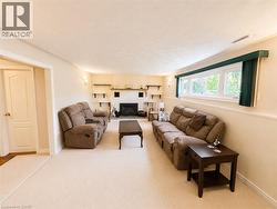 Carpeted living area featuring a white brick fireplace - 