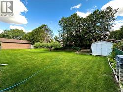 Expansive green lawn with mature trees and a dedicated garden area - 