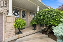 Brick facade with a covered front porch featuring white columns and a concrete pathway - 