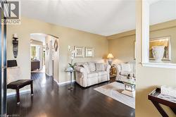 Rich wood-finish flooring extends throughout, complemented by arched doorways and a half-wall partition - 