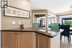 Built-in cabinetry with light wood-finish doors, polished stone countertops, and recessed lighting - 