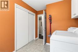 Built-in sliding closet doors, tiled flooring, and overhead cabinetry - 
