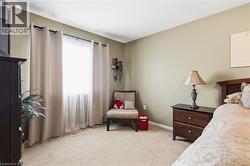 Wall-to-wall carpeting, window with sheer and blackout drapes, and a crown molding accent - 