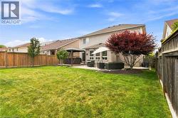 Expansive lawn, concrete patio, privacy fencing, established trees, and a gazebo structure - 
