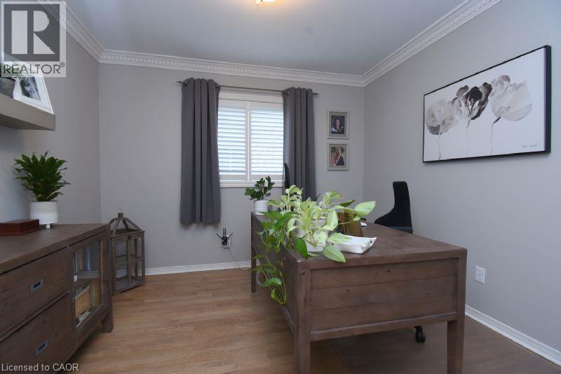 Light gray walls with crown molding, wood-finish flooring, and a window with white shutters - 470 Amanda Crescent, Burlington, ON - Indoor