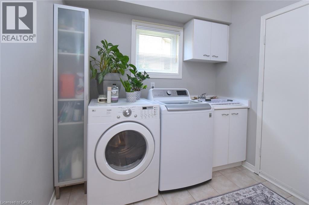 Utility room with a window, built-in cabinetry, and tile flooring - 470 Amanda Crescent, Burlington, ON - Indoor Photo Showing Laundry Room