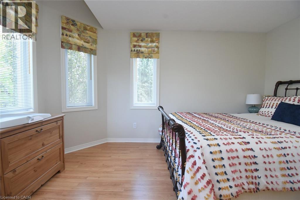 Wood-finish flooring, multiple windows with blinds, and neutral wall paint - 470 Amanda Crescent, Burlington, ON - Indoor Photo Showing Bedroom