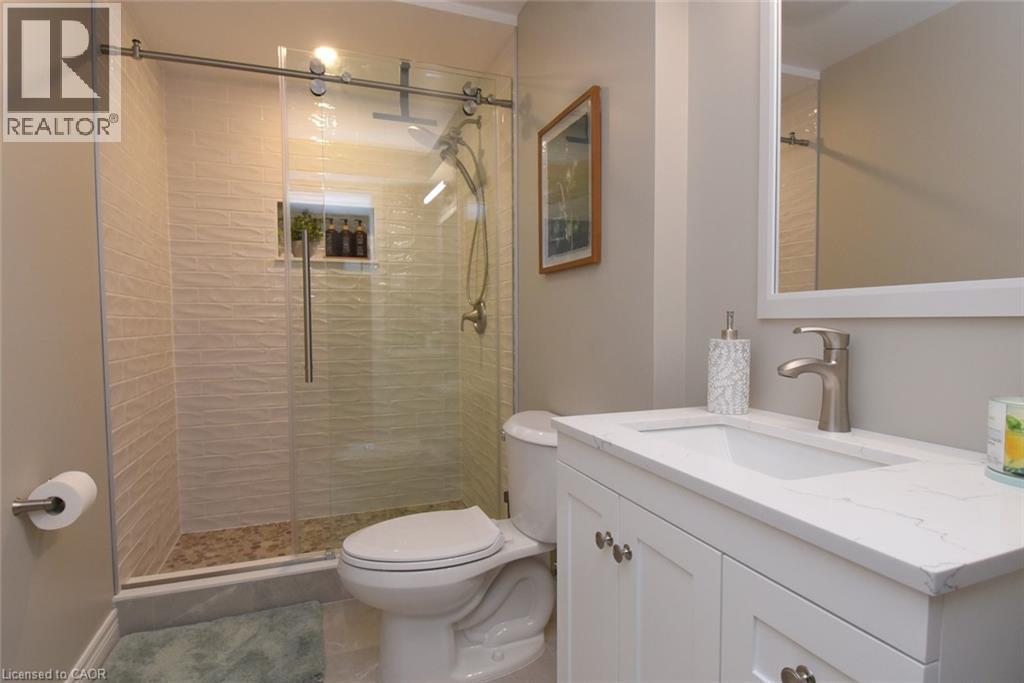 Walk-in shower with a glass enclosure and textured tile surround - 470 Amanda Crescent, Burlington, ON - Indoor Photo Showing Bathroom