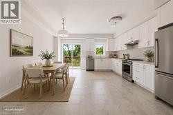 White shaker cabinetry with stainless steel appliances, stone countertops, and tile flooring - 