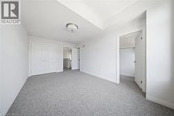 Neutral-toned carpeting, white walls, double-door closet, flush-mount ceiling light - 