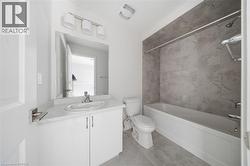 White vanity with integrated sink, rectangular mirror, and three-light fixture - 