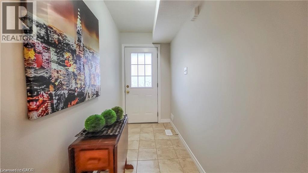 Entryway featuring a paneled door with glass inserts, neutral wall finishes, and tiled flooring - 128 Udvari Crescent Unit# A, Kitchener, ON - Indoor Photo Showing Other Room