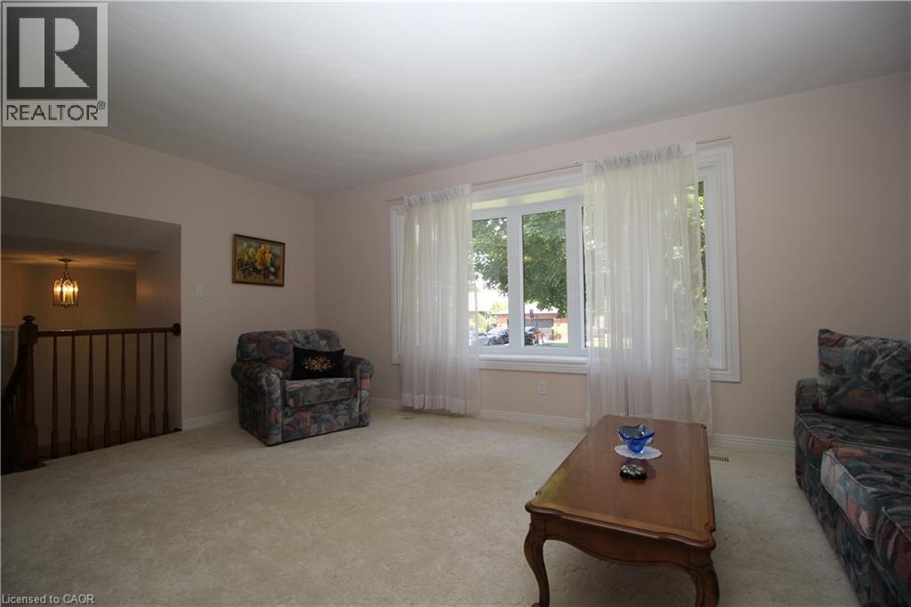 Expansive living area with neutral carpeting and light-colored walls - 14 Berkley Crescent, Simcoe, ON - Indoor
