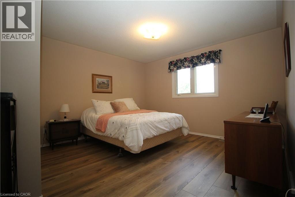 Laminate flooring, single window, flush-mount ceiling light fixture, neutral wall color - 14 Berkley Crescent, Simcoe, ON - Indoor Photo Showing Bedroom