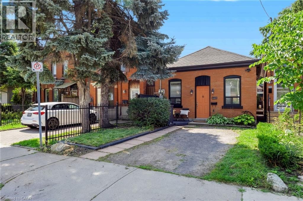 Brick exterior with dark trim accents, gabled roof, and orange front entry door - 442 King William Street, Hamilton, ON - Outdoor