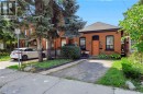 Brick exterior with dark trim accents, gabled roof, and orange front entry door - 442 King William Street, Hamilton, ON  - Outdoor 