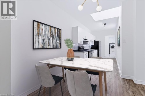 Open-concept dining area with wood-finish flooring, featuring a skylight and contemporary overhead lighting - 442 King William Street, Hamilton, ON - Indoor Photo Showing Dining Room