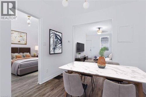 Open concept dining area featuring a marble-patterned tabletop, wood-finish flooring, and recessed lighting - 442 King William Street, Hamilton, ON - Indoor