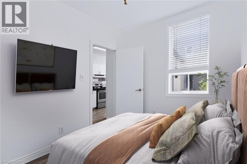 White walls with wood-finish flooring - 442 King William Street, Hamilton, ON - Indoor Photo Showing Bedroom