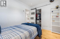 Hardwood flooring, recessed lighting, crown molding, barn door closet, and white walls - 