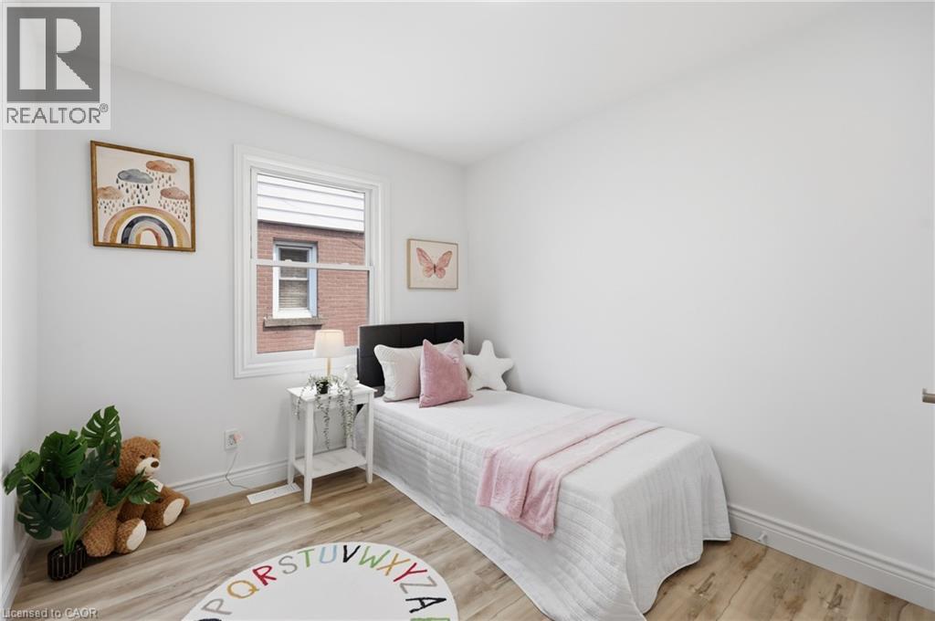 Light wood-finish flooring, white walls, and a single window with white trim - 156 East 36Th Street, Hamilton, ON - Indoor Photo Showing Bedroom
