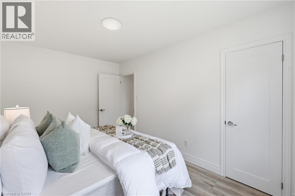 White walls with wood-finish flooring, two panel doors, and flush-mount ceiling lighting - 156 East 36Th Street, Hamilton, ON - Indoor Photo Showing Bedroom