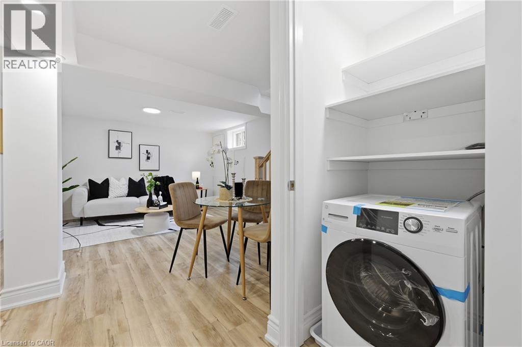 Integrated laundry appliance with built-in shelving, wood-finish flooring, recessed lighting, and white walls - 156 East 36Th Street, Hamilton, ON - Indoor Photo Showing Laundry Room
