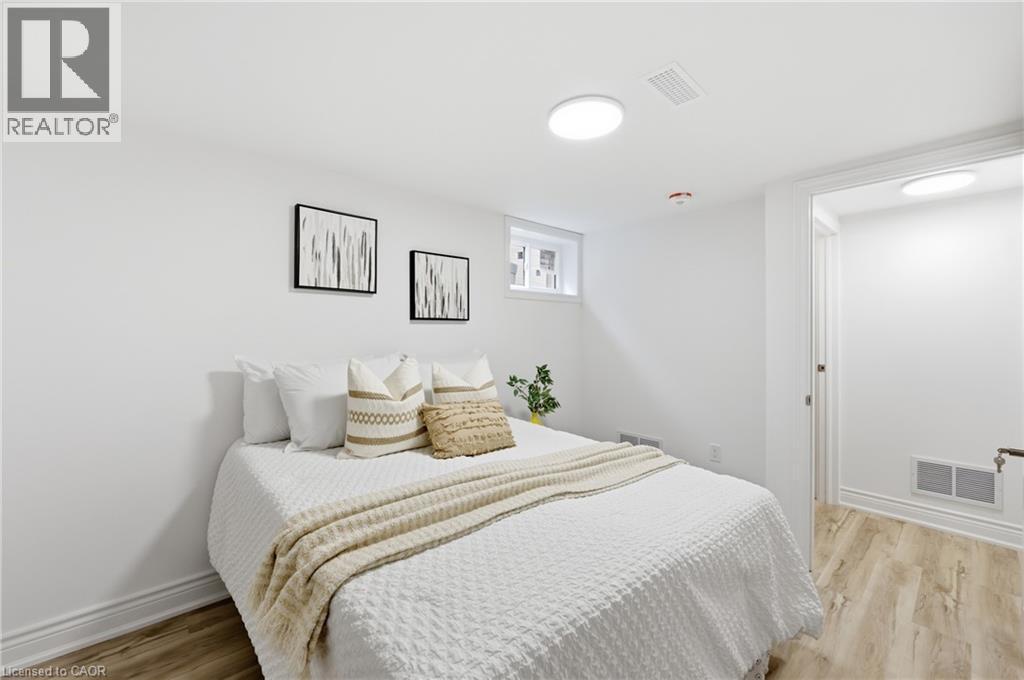 Recessed window, wood-finish flooring, white walls, white trim, and ceiling-mounted lighting fixtures - 156 East 36Th Street, Hamilton, ON - Indoor Photo Showing Bedroom