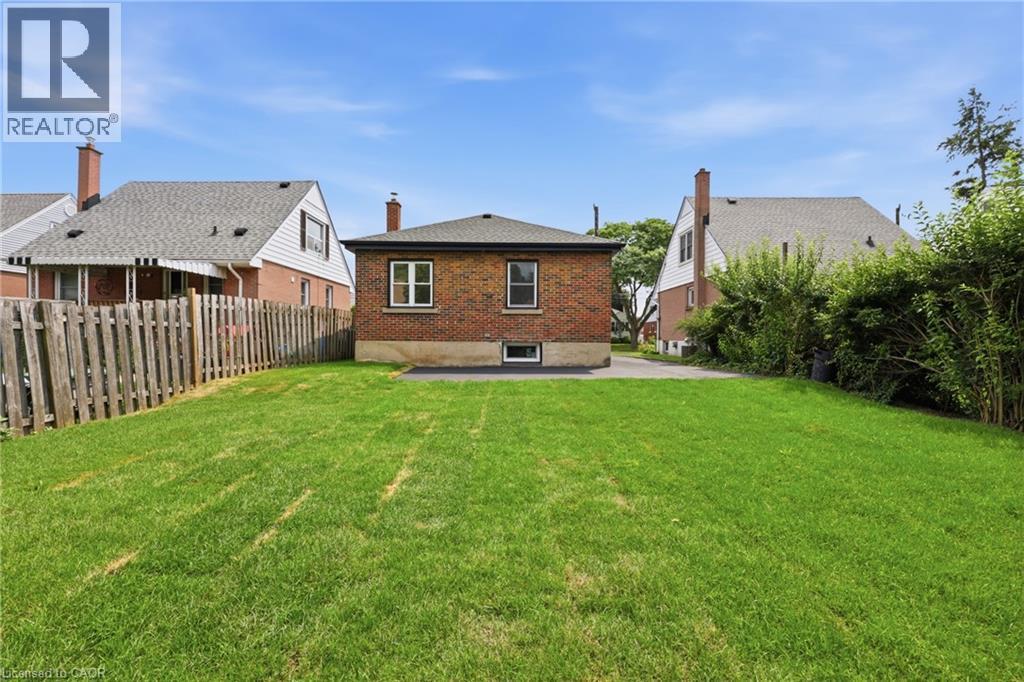Expansive grassy yard with a wooden privacy fence and mature perimeter landscaping - 156 East 36Th Street, Hamilton, ON - Outdoor