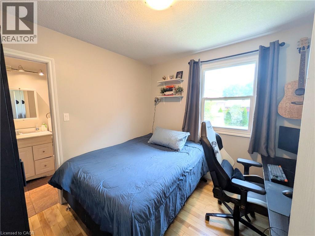 Hardwood-style flooring, white trim, recessed lighting, and a single window - 7 Campbell Avenue, Hamilton, ON - Indoor Photo Showing Bedroom