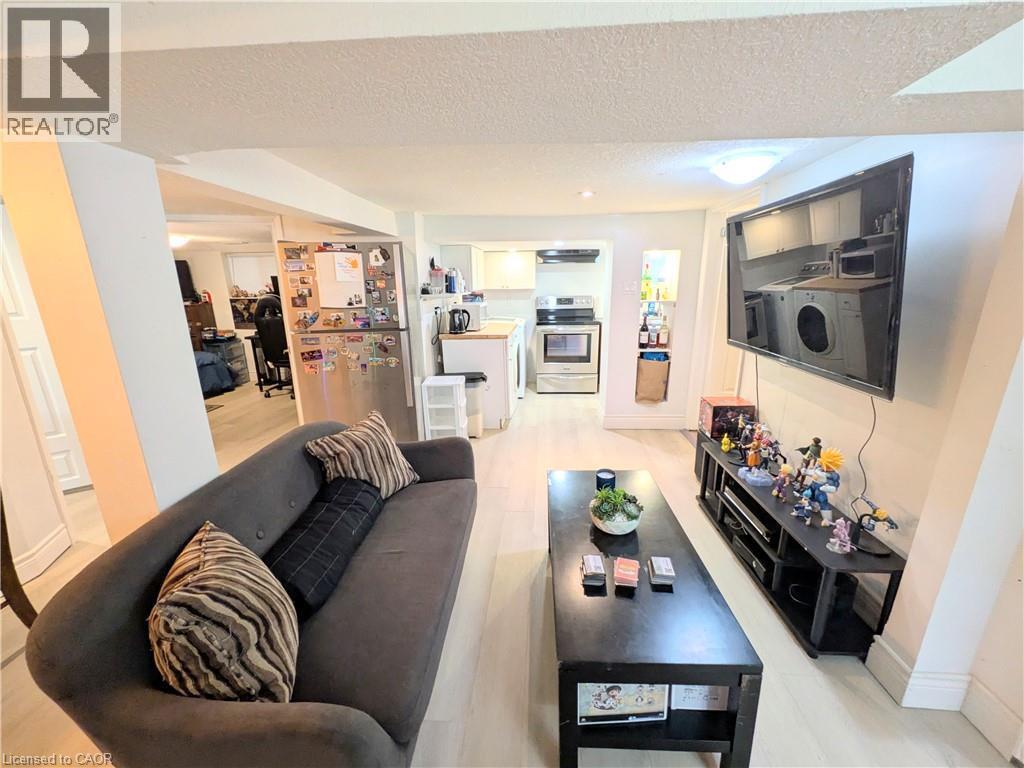 Light wood-finish flooring, recessed ceiling lighting, stainless steel appliances, and built-in shelving - 7 Campbell Avenue, Hamilton, ON - Indoor Photo Showing Living Room