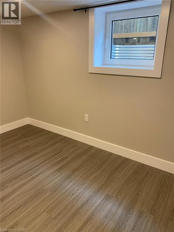 Wood-finish flooring with white baseboards - 361 Prospect Avenue, Kitchener, ON - Indoor Photo Showing Other Room