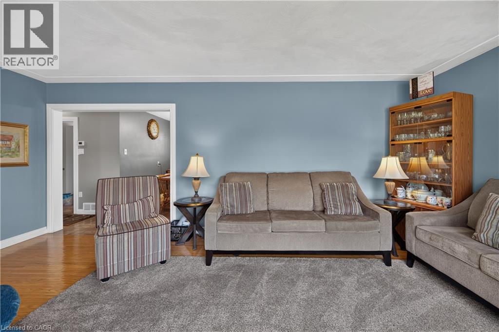 Hardwood flooring, painted walls, carpeted area, crown molding, and a built-in display cabinet - 5 Kentley Drive, Hamilton, ON - Indoor Photo Showing Living Room